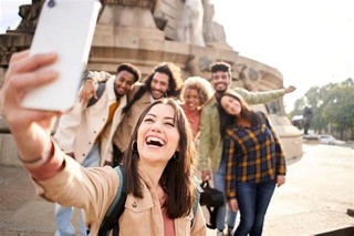 A group of friends laughing and taking a selfie together while travelling